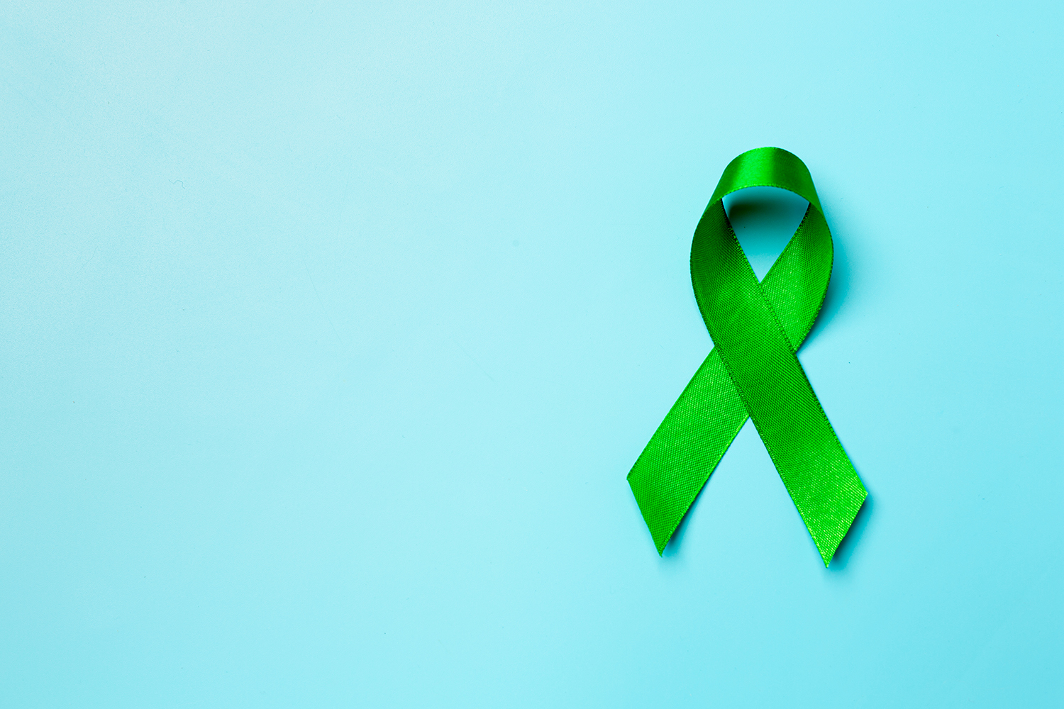Grüne Schleife vor blauen Hintergrund
