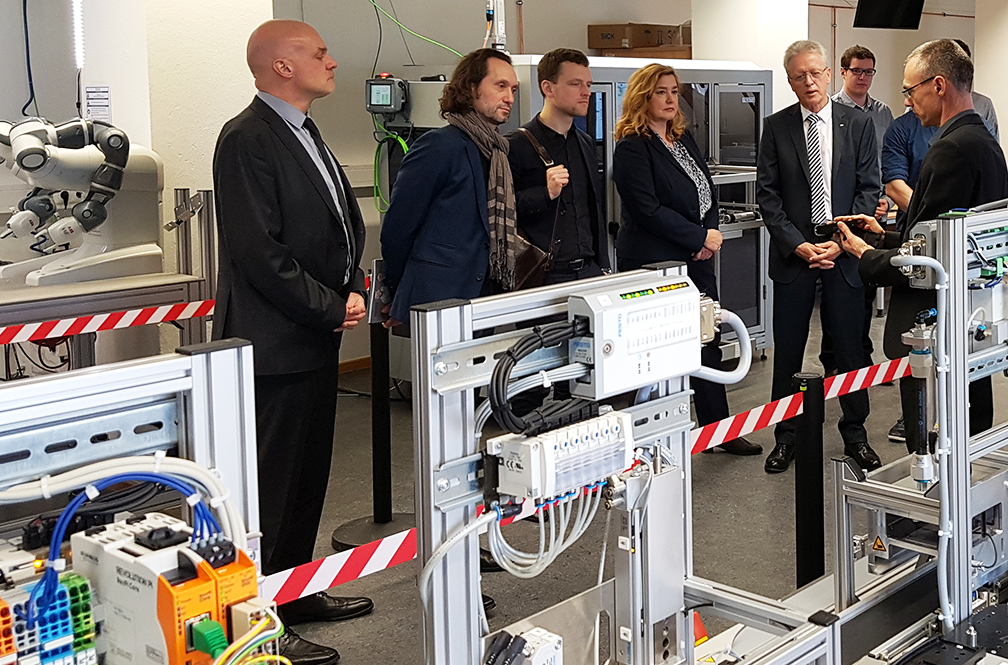 Max Strotmann (Mitarbeiter der EU-Kommission) und Vertreter des SMWA besuchten die Modellfabrik Industrie 4.0