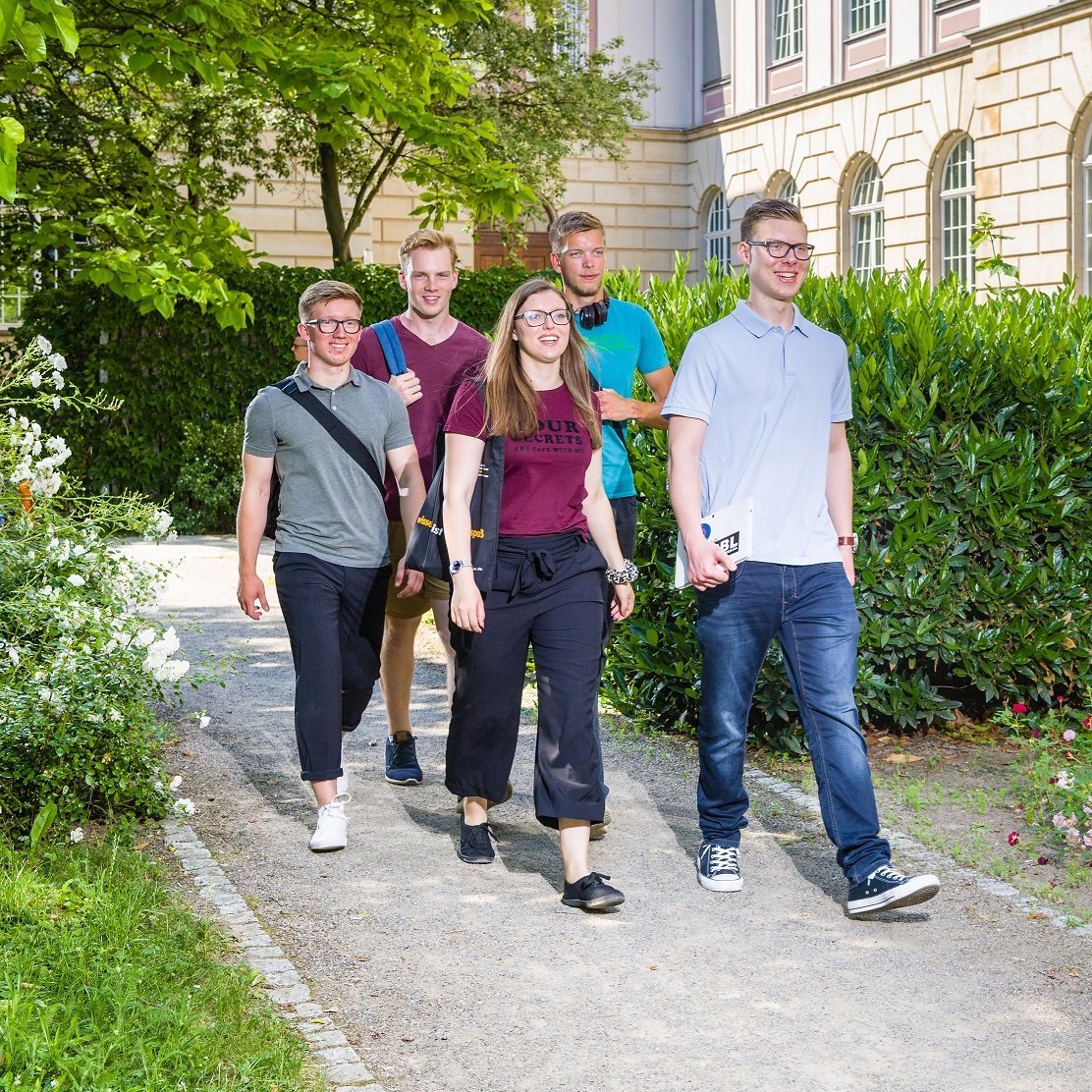 Studierende laufen durch den Rosengarten
