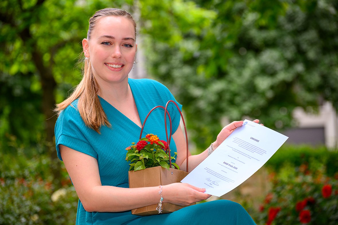 Junge Frau hält Urkunde in der Hand